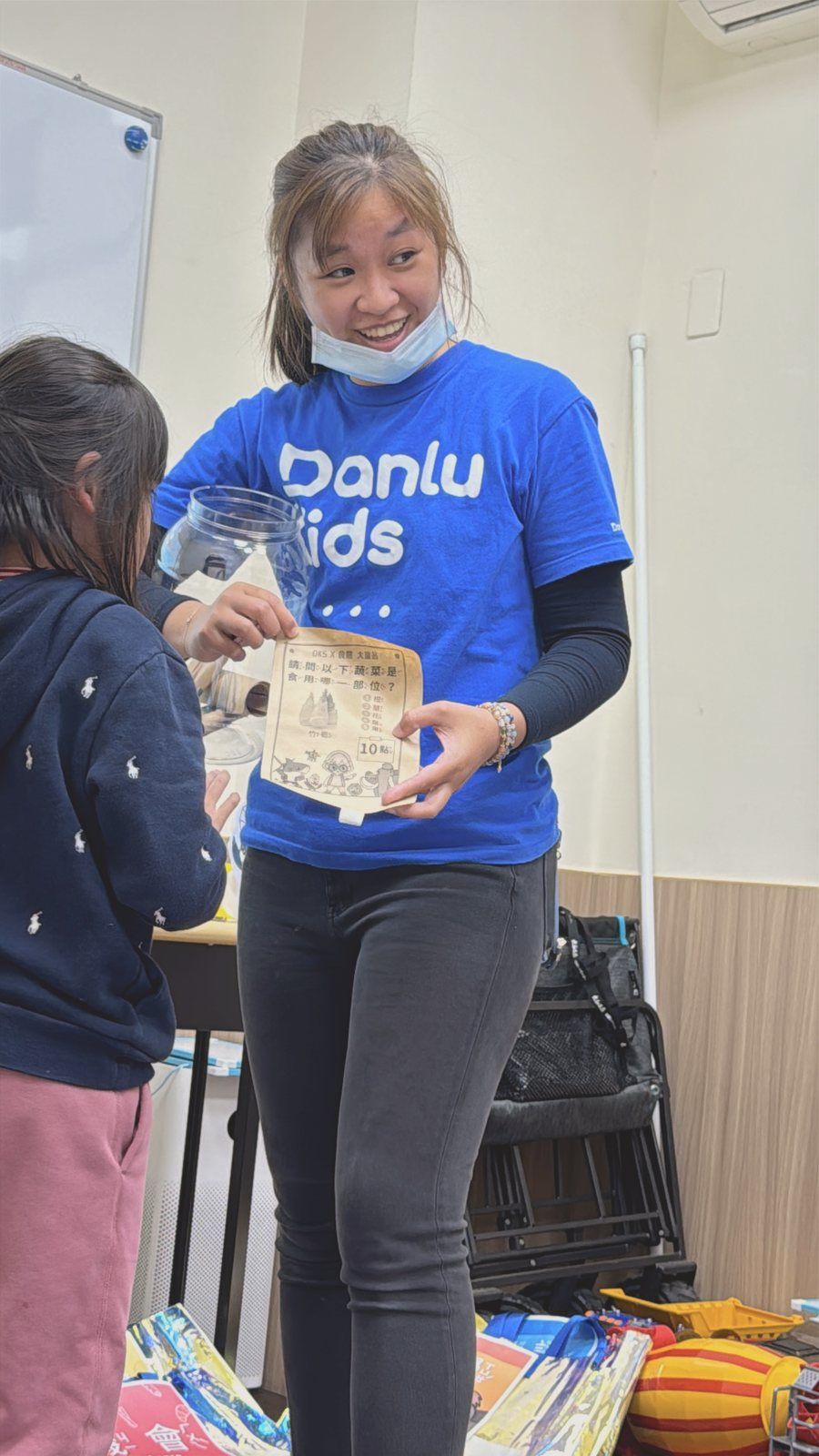 老師拿著學習單和孩子互動