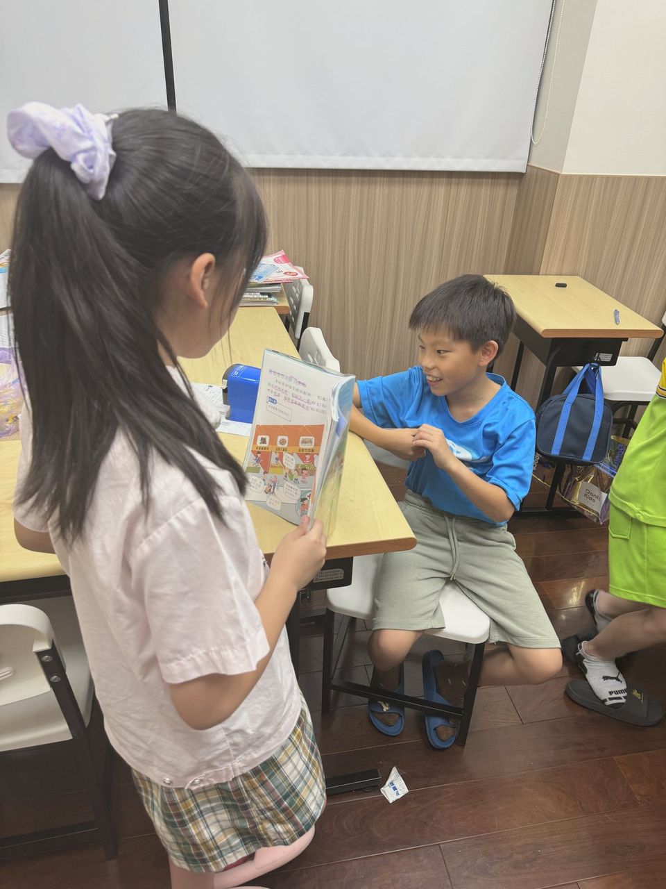 孩子們拿著課本互相提問