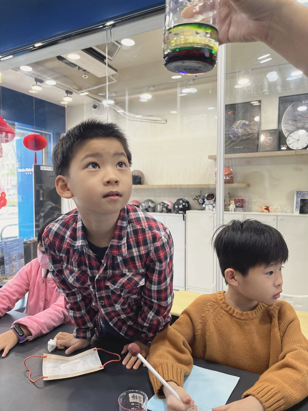 孩子好奇地看著老師示範實驗
